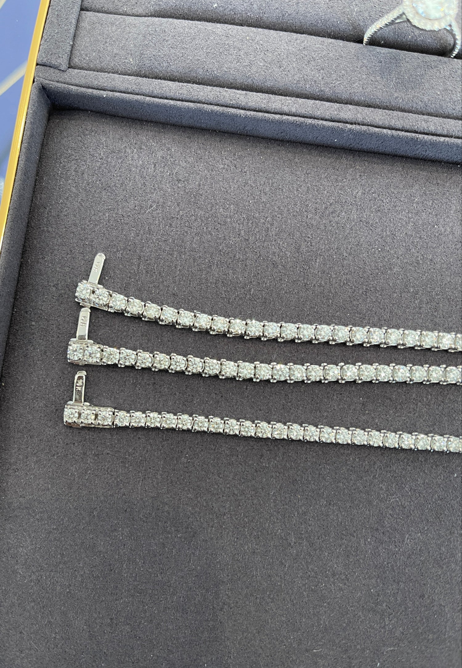 Diamond tennis necklace on a gray jewelry display box
